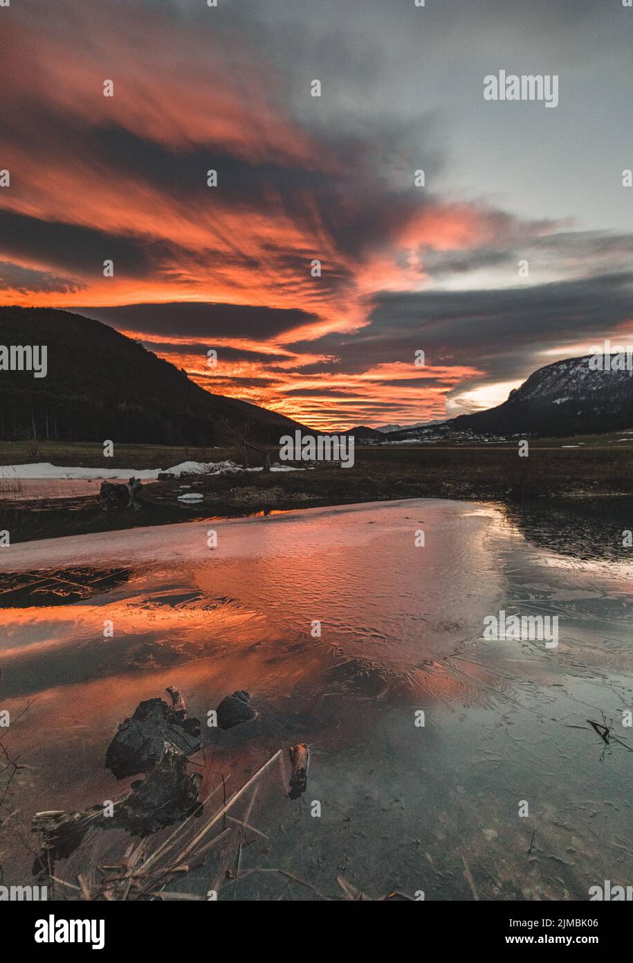 Tramonto rosso in un lago ghiacciato in inverno Foto Stock