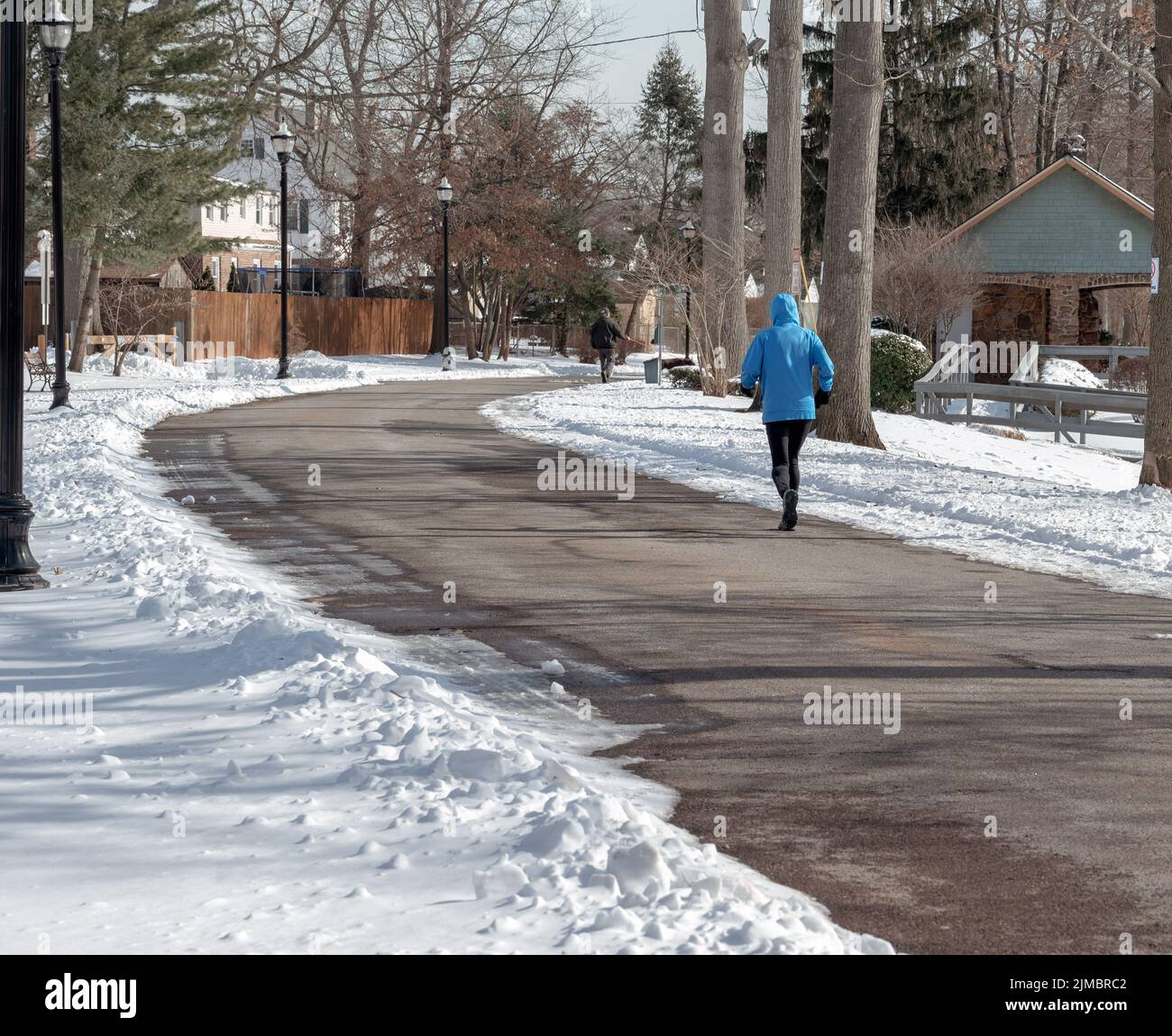 Donna che corre nel parco cittadino a freddo giorno d'inverno. Concetto di salute e stile di vita. Fitness invernale. Foto Stock
