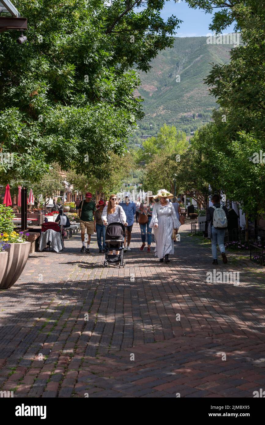 Il gruppo del tour è condotto da una guida in costume vittoriano, camminando nella Aspen Pedestrian Plaza sul marciapiede realizzato con antichi mattoni finitrici, nel centro di Aspen, Colo, USA. Foto Stock
