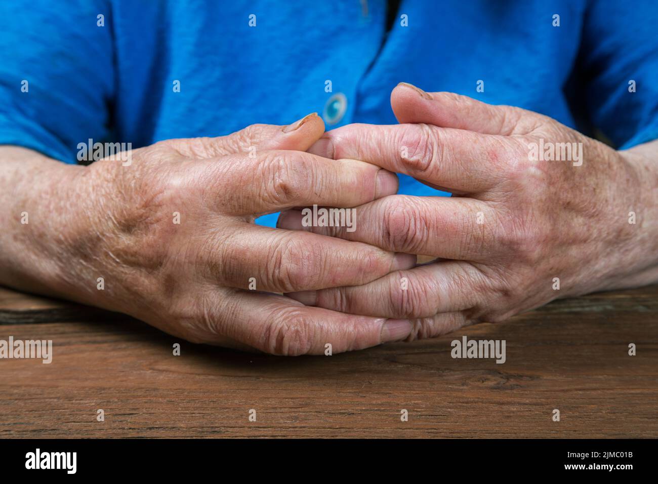 Vecchie mani femminili su un tavolo rustico vintage Foto Stock