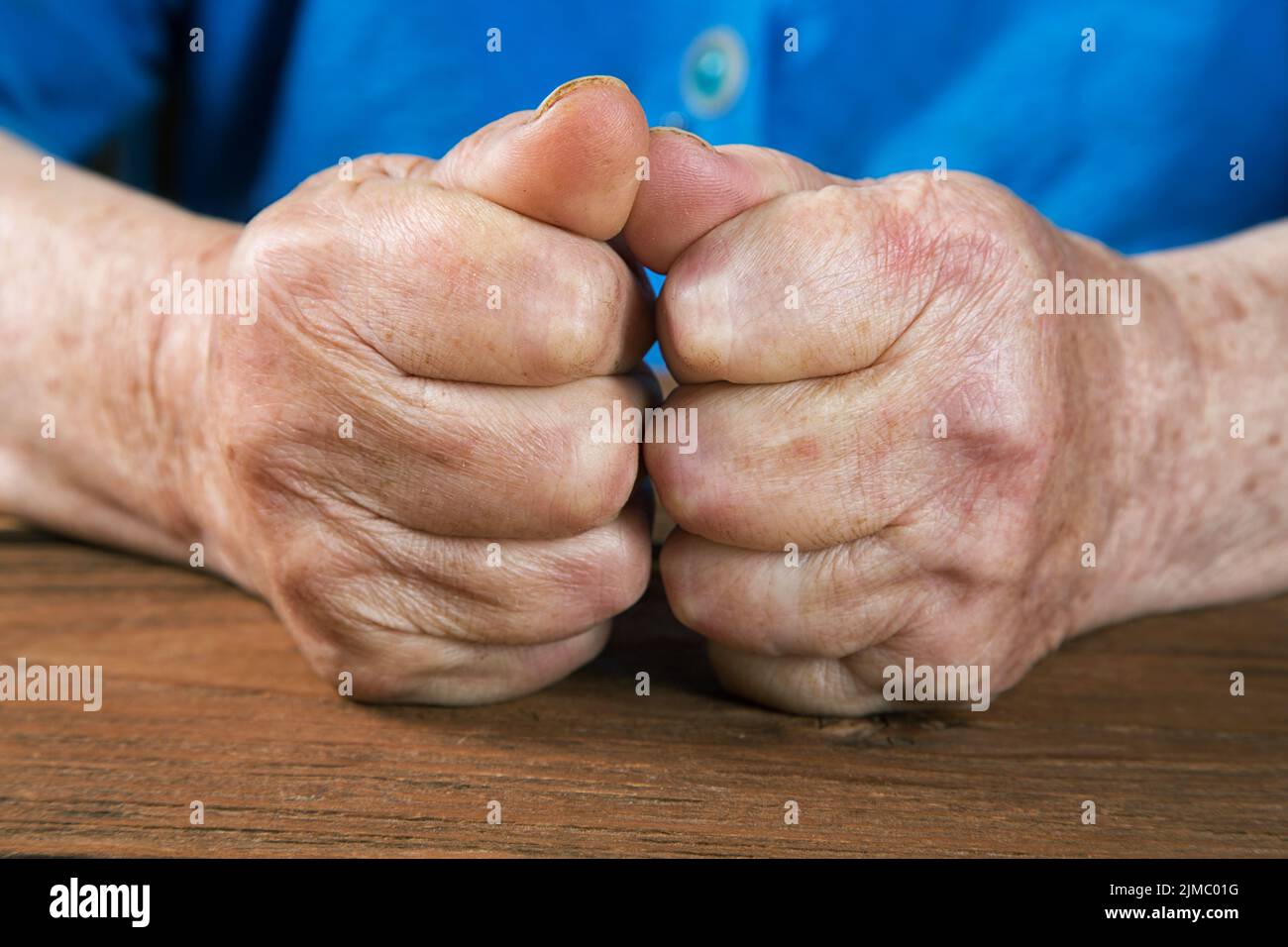 Vecchie mani femminili su un tavolo rustico vintage Foto Stock