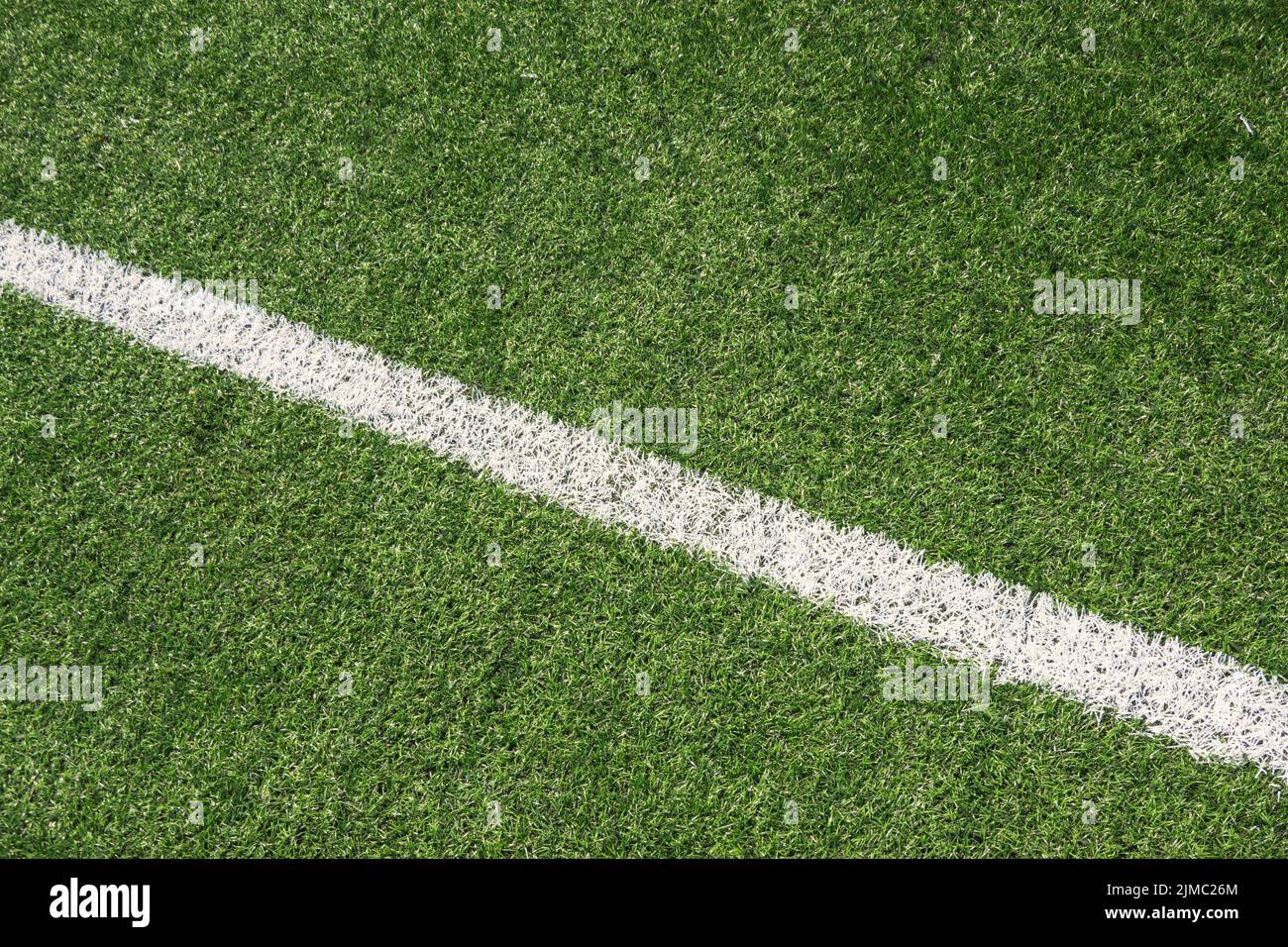 Campo sportivo di calcio verde sintetico in erba sintetica con linea bianca Foto Stock