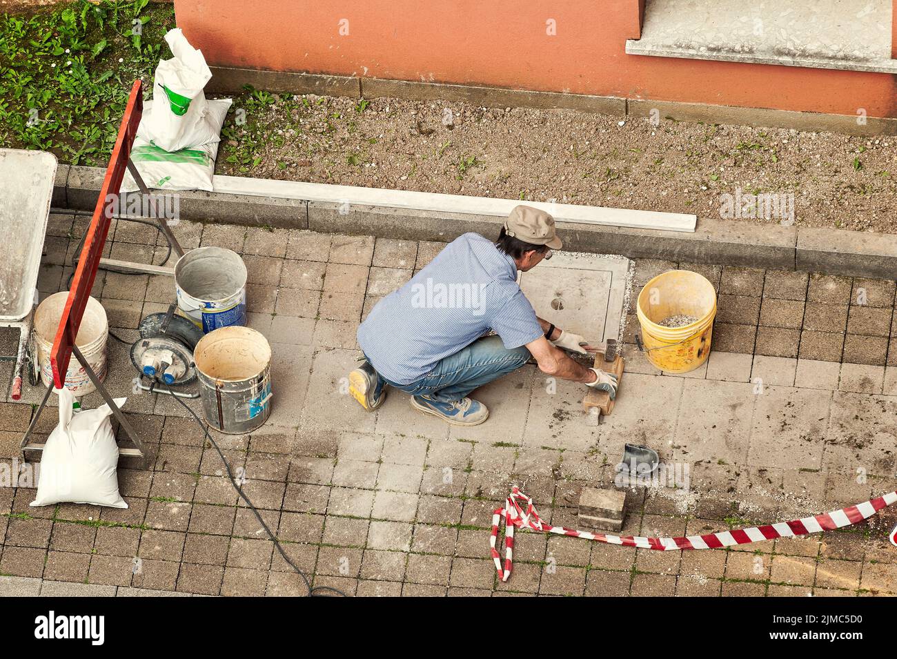 Muratore al lavoro la posa di blocchi di pietra. Foto Stock