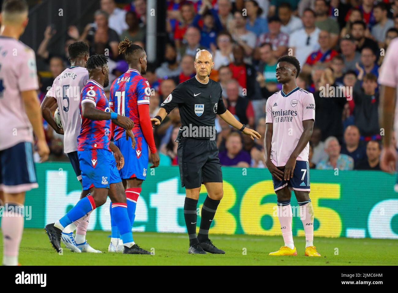 Londra, Regno Unito. 5th agosto 2022; Selhurst Park, Crystal Palace, Londra, Inghilterra; Premier League Football, Crystal Palace Versus Arsenal: Arbitro Anthony Taylor tenere a parte Wilfried Zaha del Crystal Palace e Bukayo Saka dell'Arsenal credito: Action Plus Sports Images/Alamy Live News Foto Stock