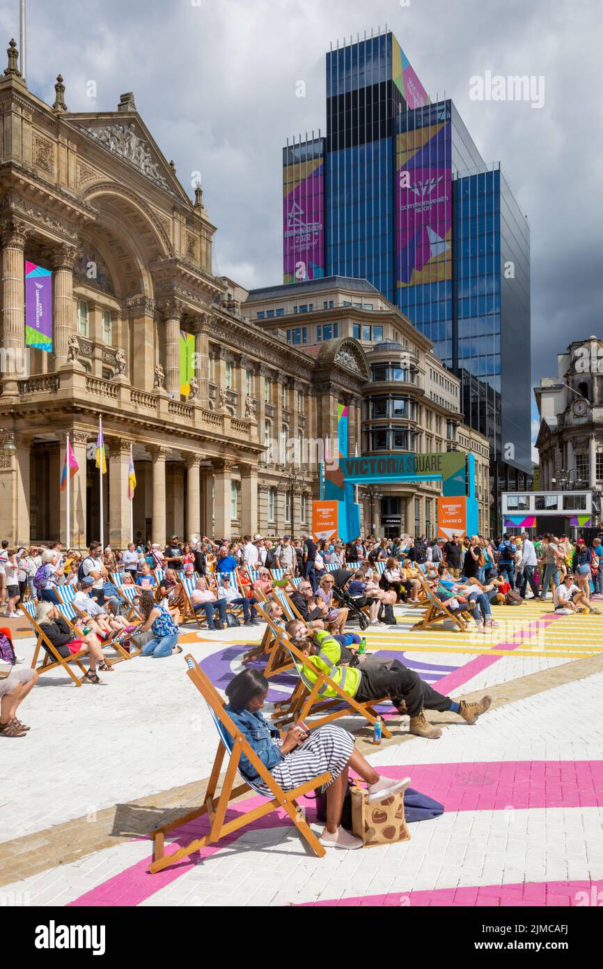 Una folla di spettatori che si godono il sole estivo in Victoria Square Birmingham guardando un grande schermo Commonwealth Games 2022 Foto Stock