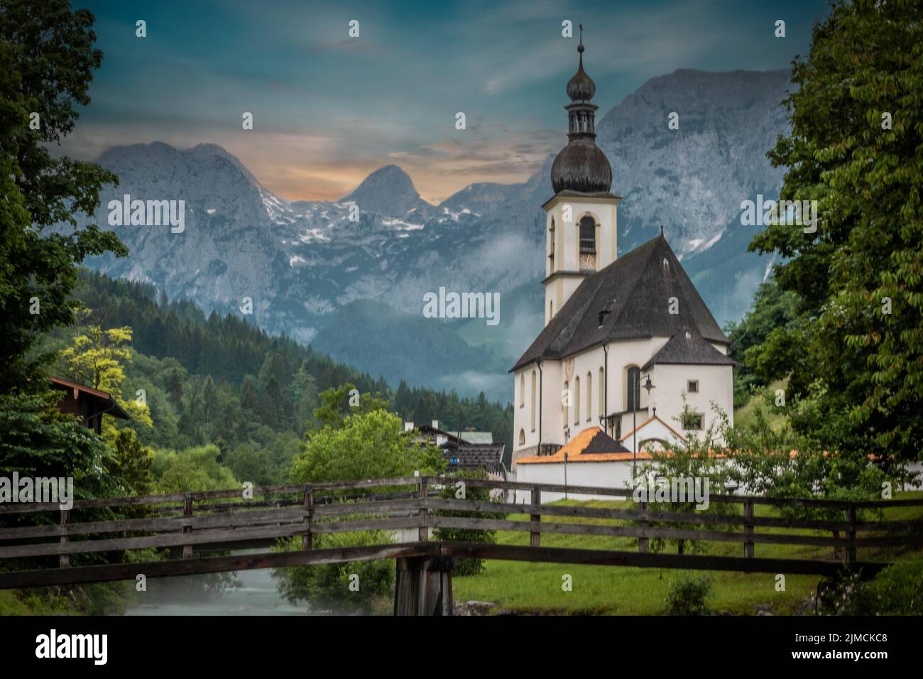 Chiesa parrocchiale di San Sebastiano, con ponte in legno su un torrente, lunga esposizione, Ramsau, Berchtesgadener Land, alta Baviera, Baviera, Germania Foto Stock