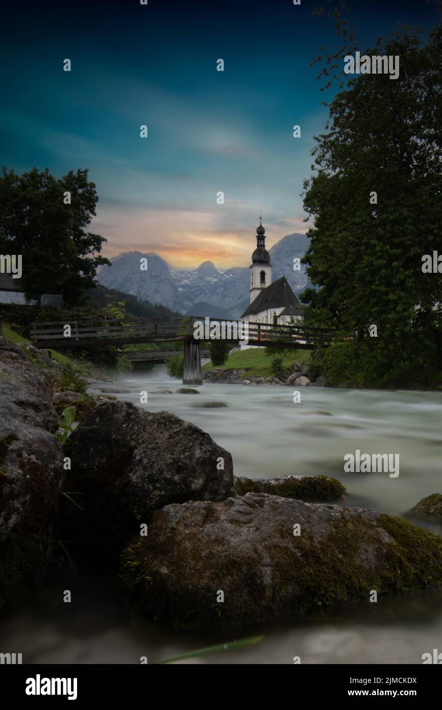 Chiesa parrocchiale di San Sebastiano, con ponte in legno su un torrente, lunga esposizione, Ramsau, Berchtesgadener Land, alta Baviera, Baviera, Germania Foto Stock