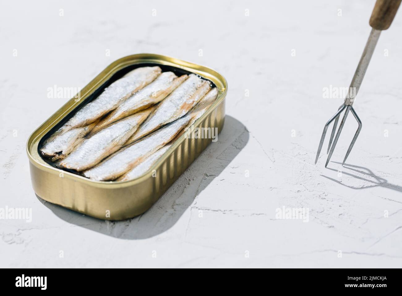 Lattina di sardine aperta a metà su sfondo bianco Foto Stock
