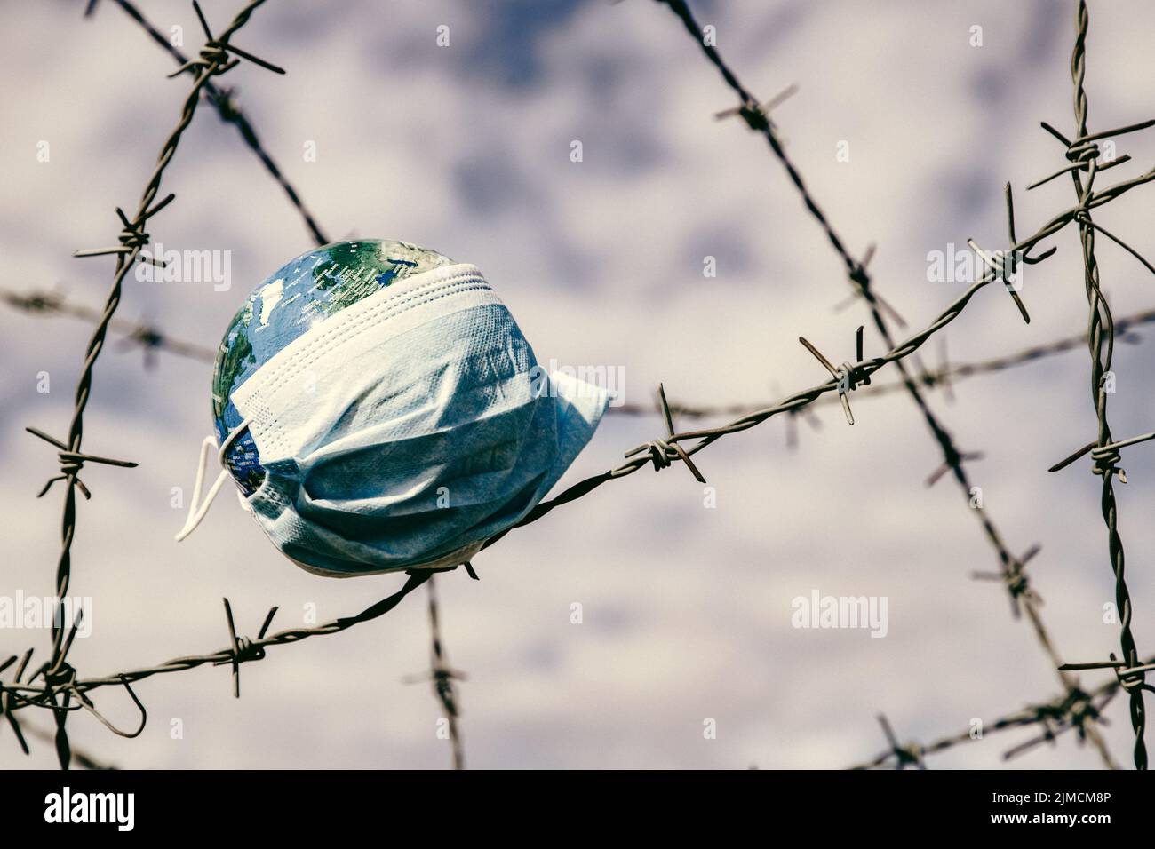 Coronavirus Global Fight Concept - COVID-19 - maschera facciale sul globo Foto Stock