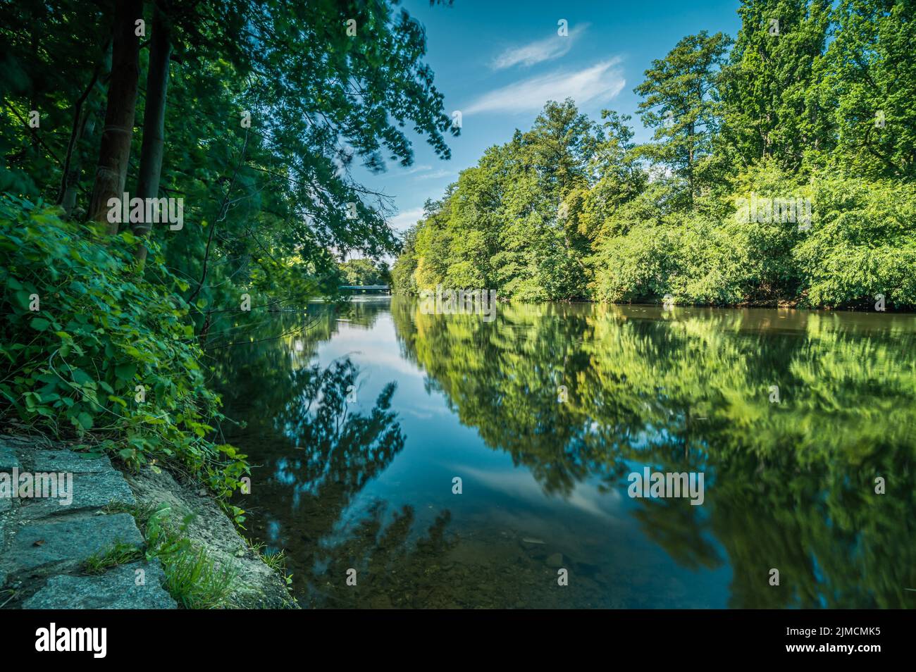 Lunga esposizione del fiume Saale a Jena con riflessi di alberi decidui in acqua, Jena, Turingia, Germania Foto Stock