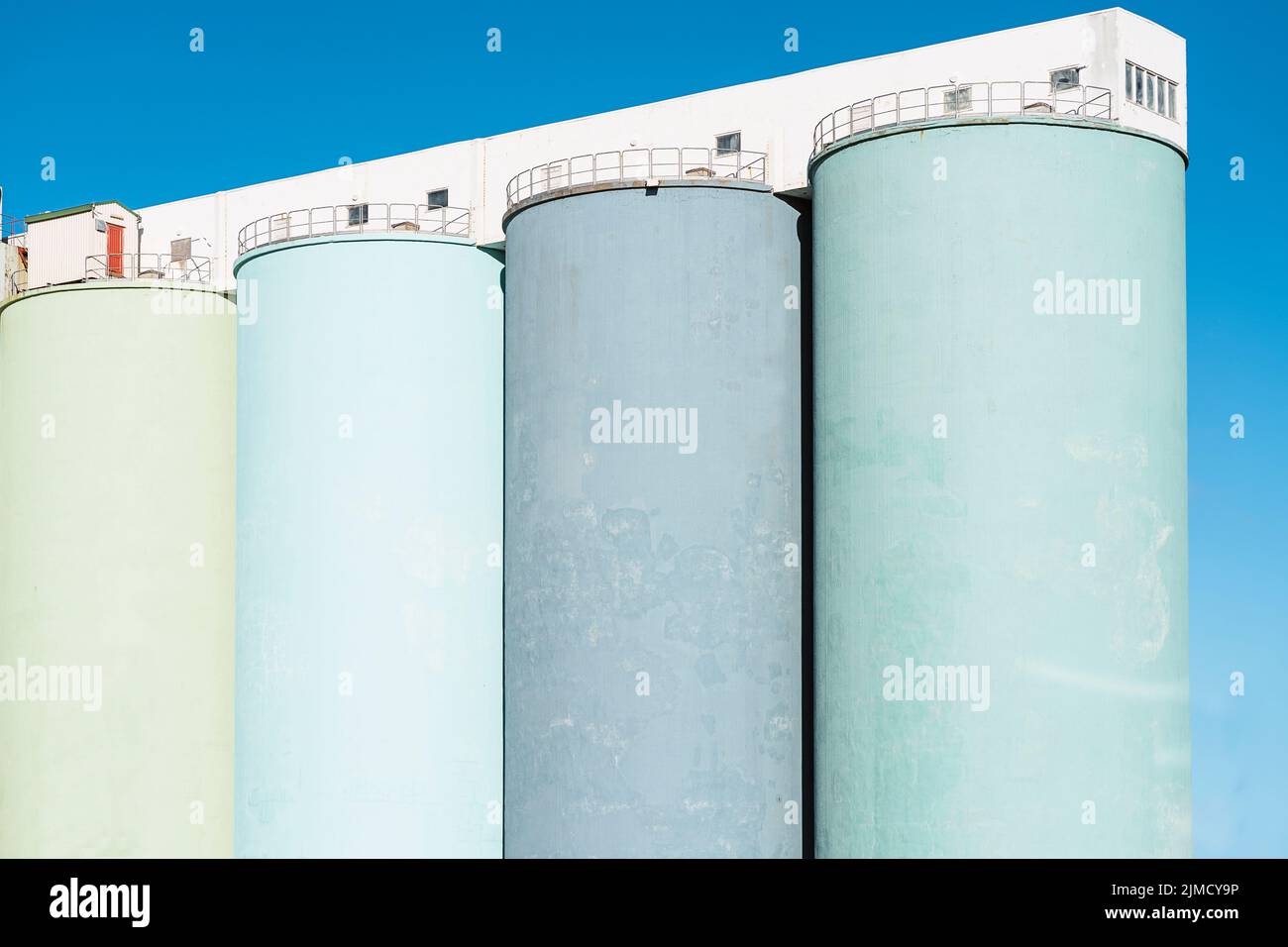 Basso angolo di enormi serbatoi di stoccaggio del petrolio contro il cielo blu senza nuvole nella giornata di sole in Islanda Foto Stock