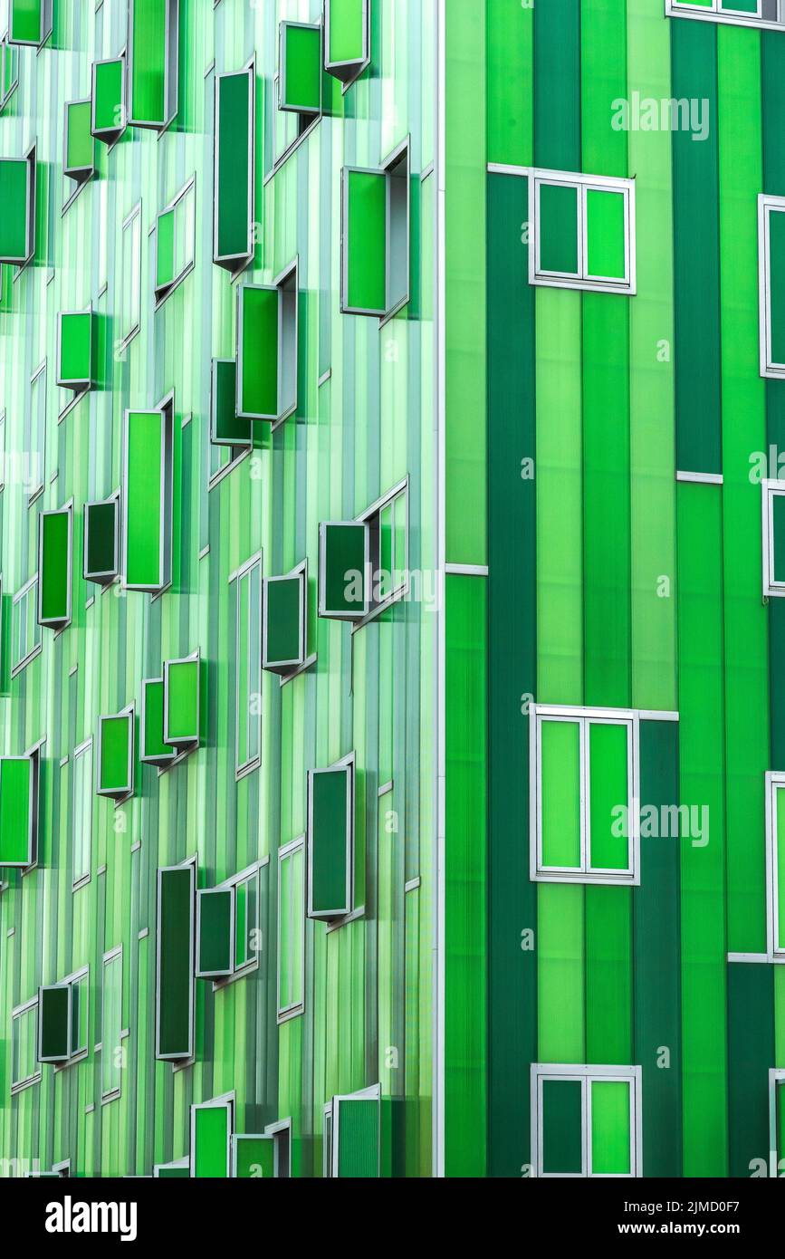 Edificio contemporaneo con una facciata verde vivida e finestre aperte Foto Stock