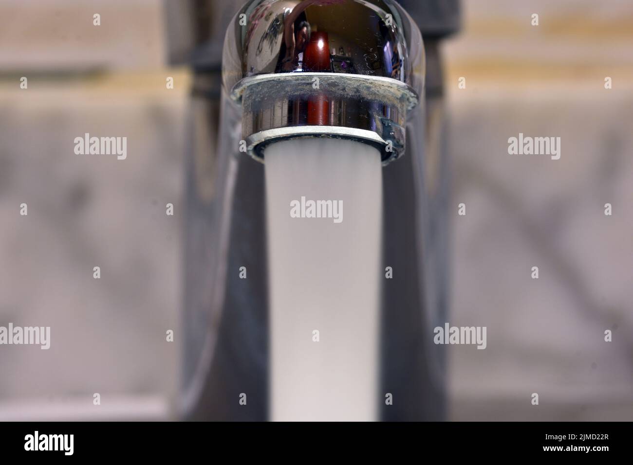 Chorro de agua cayendo de un grifo de un lavabo Foto Stock