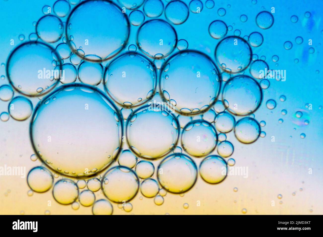 Sfondo astratto delle bolle d'olio sulla superficie dell'acqua tavolozza colorata ciano arancione. Foto Stock