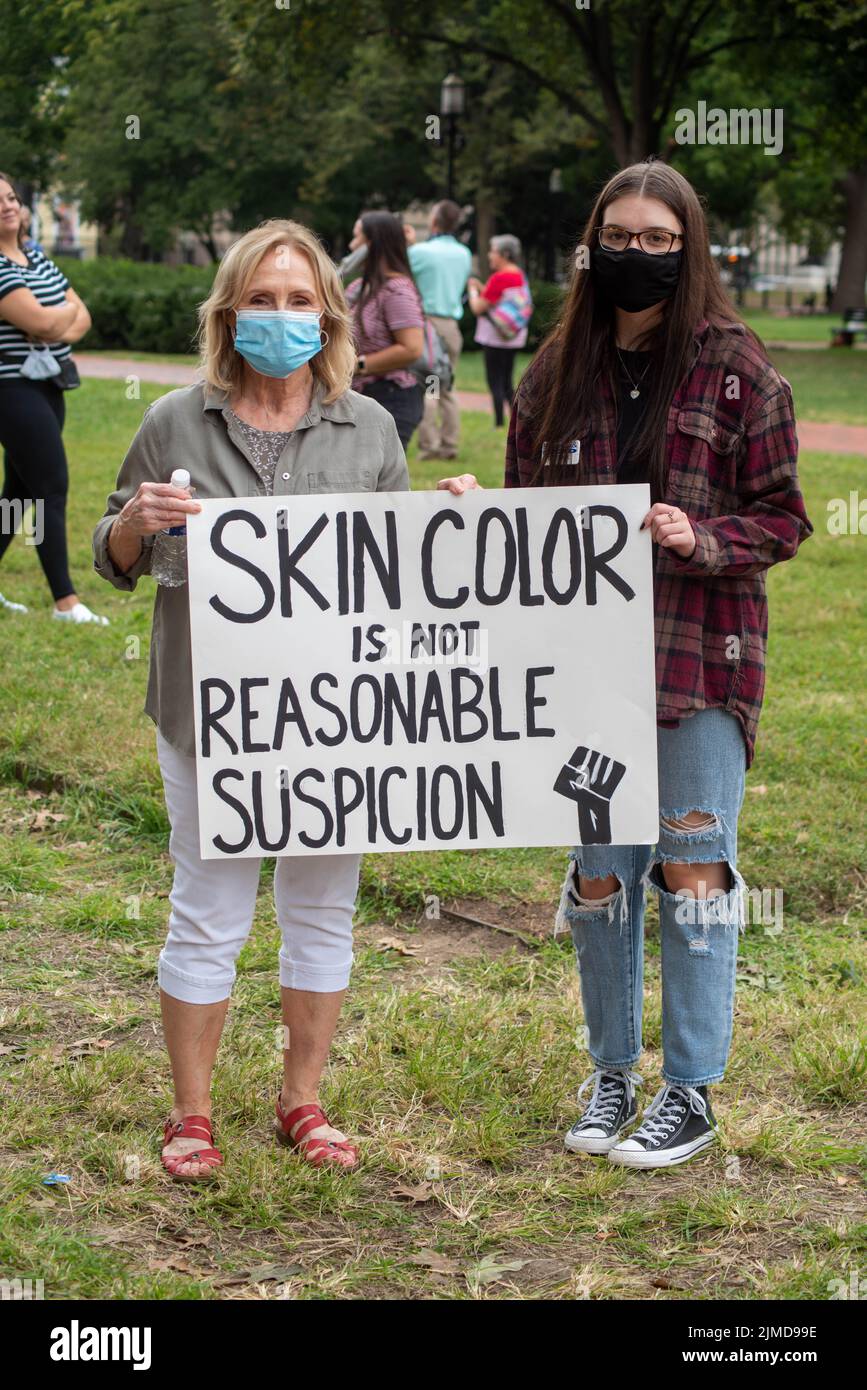 Due donne hanno un segno di protesta contro il razzismo Foto Stock