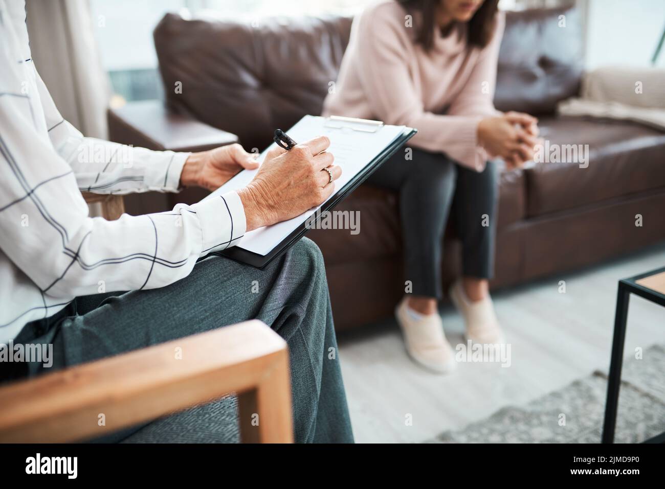 L'aiuto è disponibile quando vi sentite sopraffatti. Uno psicologo che scrive le note durante una sessione terapeutica con il suo paziente. Foto Stock