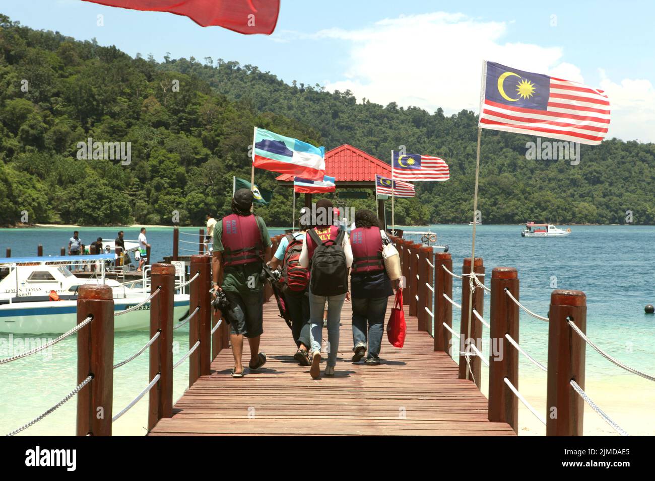 Un gruppo di giornalisti che camminano su un molo a Pulau Sapi (Isola Sapi), durante un viaggio mediatico organizzato da Air Asia all'interno dell'area di Tunku Abdul Rahman Park a Sabah, Malesia. Foto Stock