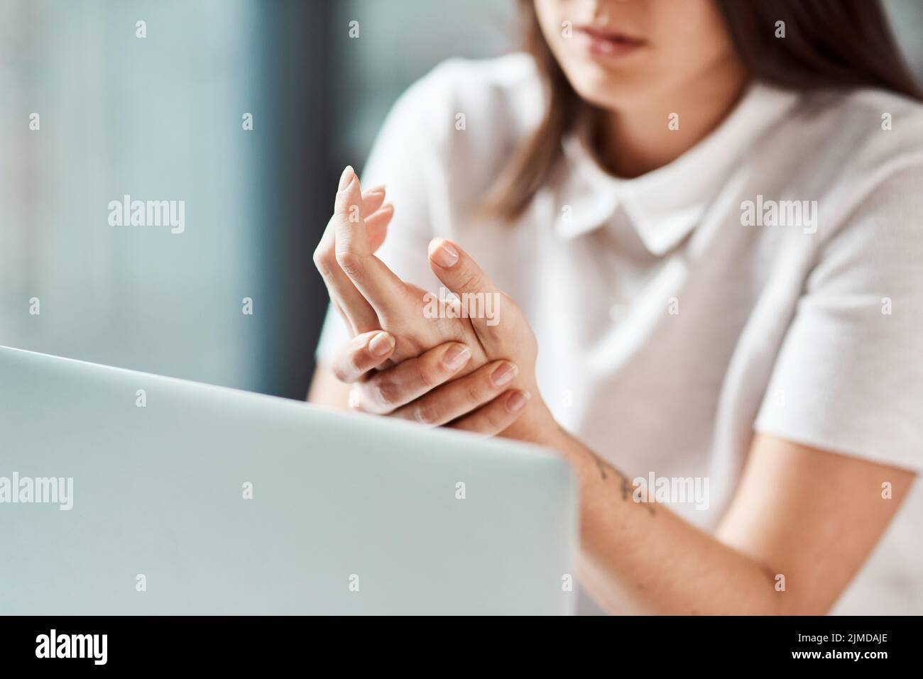 Sentendo lo sforzo sui tendini dei suoi polsi e delle sue mani. Primo piano di un'irriconoscibile donna d'affari che sperimenta disagio in mano mentre Foto Stock