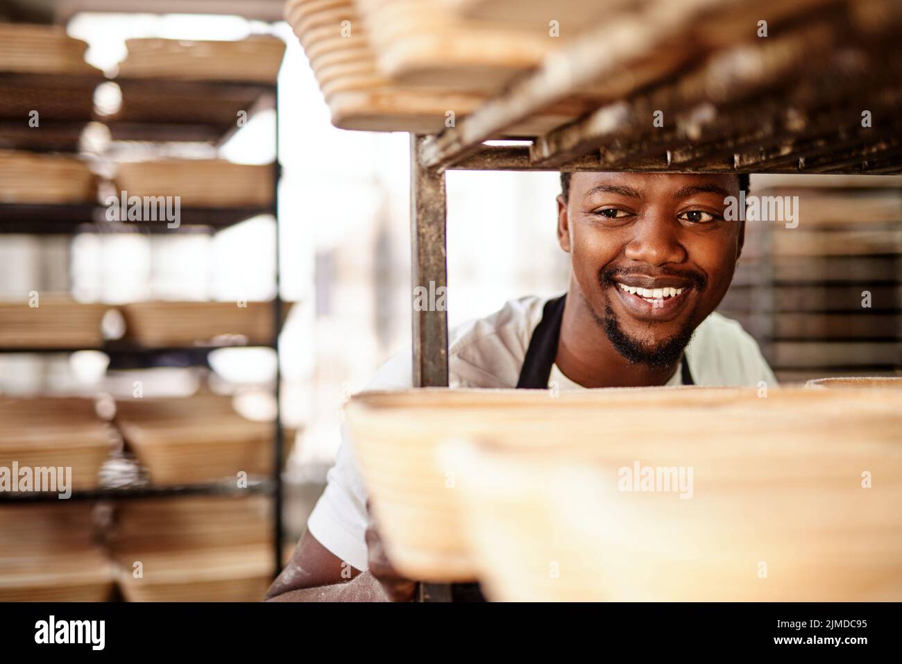 Niente mi rende più felice della cottura. Un panettiere maschio che spinge un carrello da forno. Foto Stock