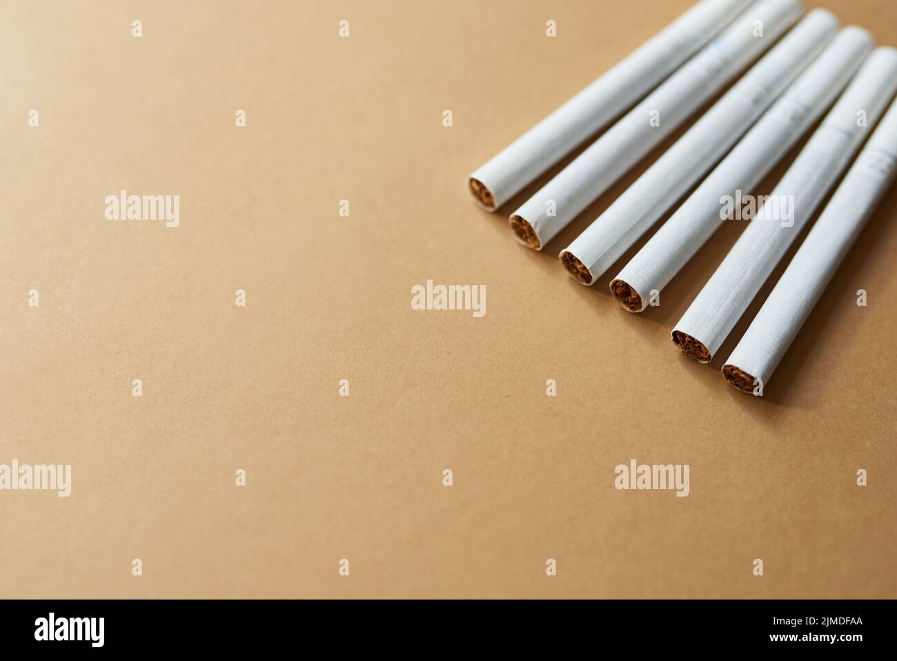 Qualcuno ha detto che il fumo si è interrotto. Studio girato di una fila di sigarette su uno sfondo marrone. Foto Stock