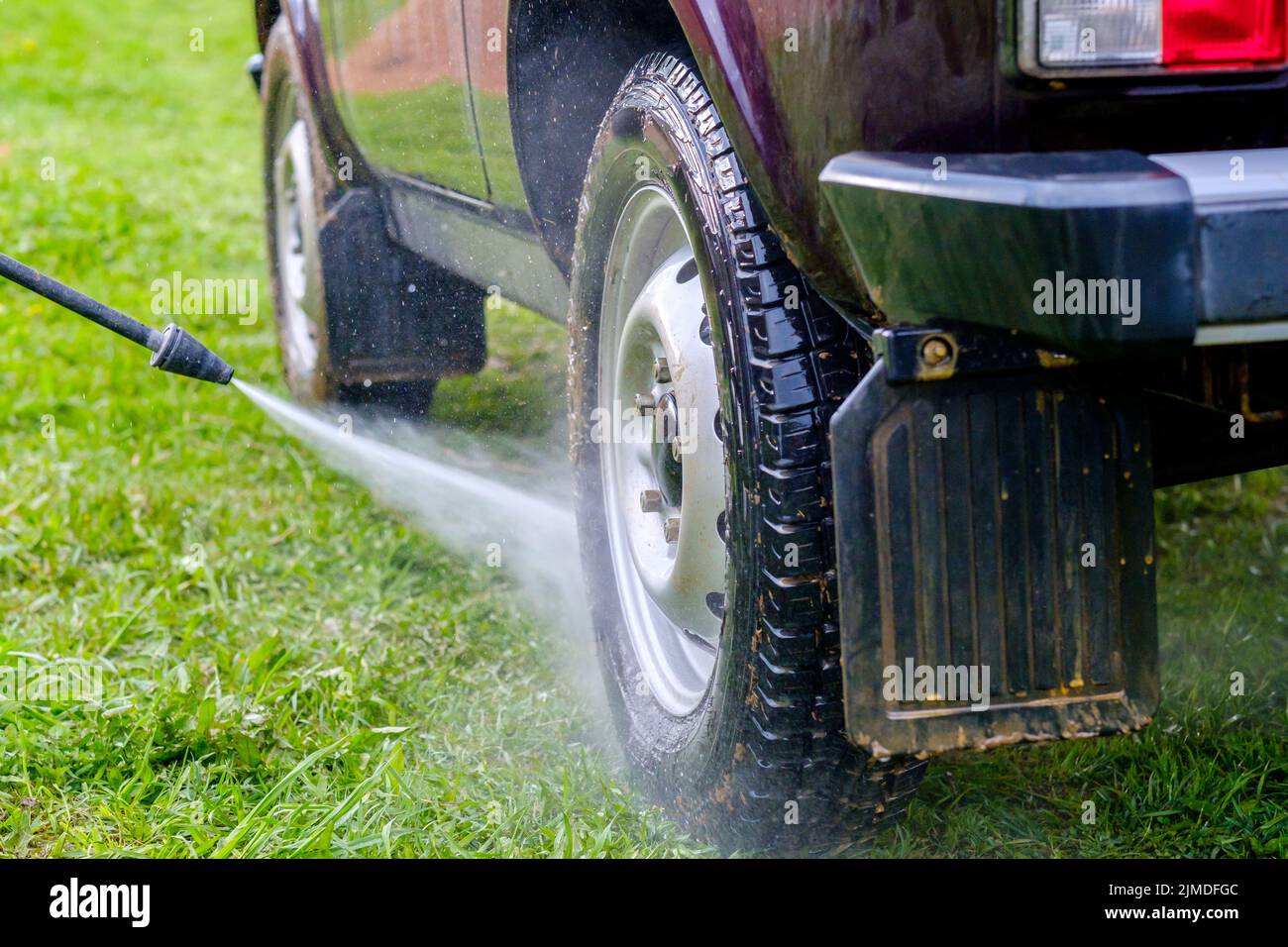 Autolavaggio pomeridiano all'aperto con apparecchio ad alta pressione. Foto Stock