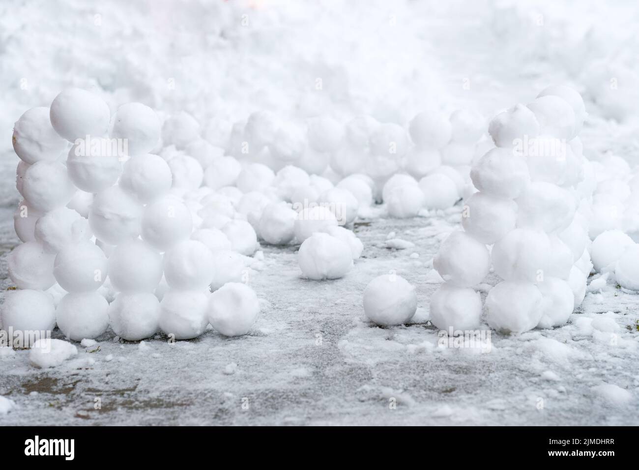 Ci sono molte palle di neve rotonde nella neve. Divertimento invernale. Astratto nuovo anno natale sfondo. Spazio di copia. Foto Stock