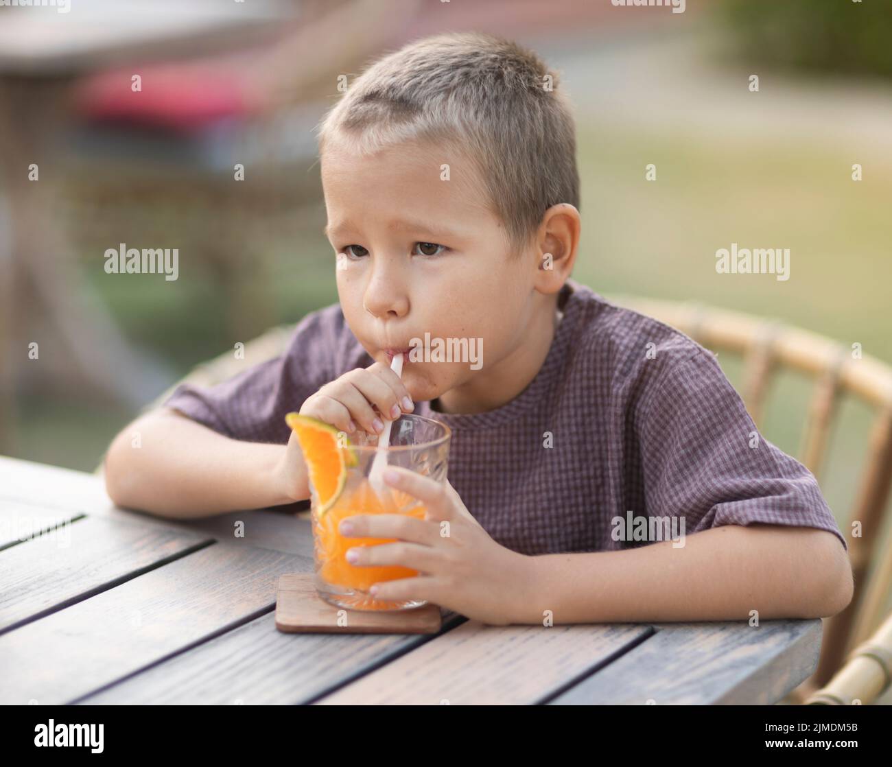 Un ragazzo che mangia un gelato nella caffetteria all'aperto Foto Stock