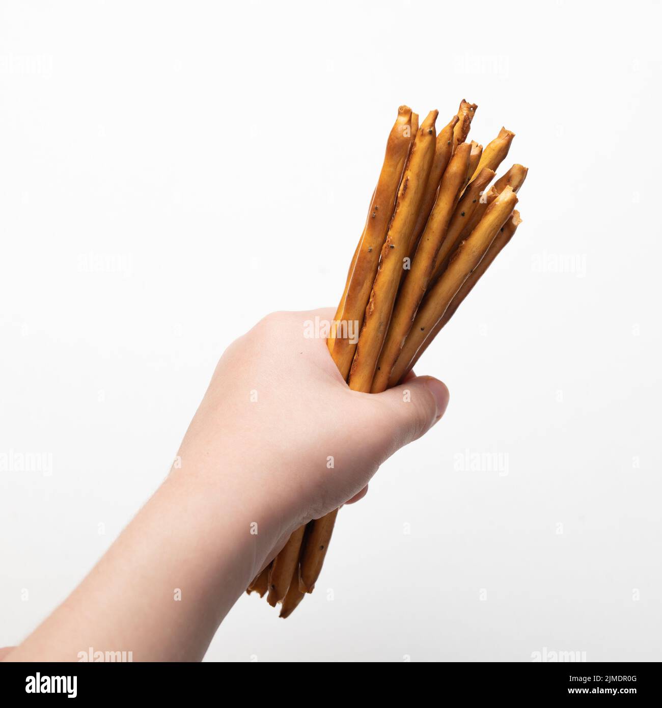 Mano del bambino che tiene grissini croccanti isolati su fondo bianco Foto Stock Mano del bambino che tiene grissini croccanti isolati su fondo bianco Foto Stock