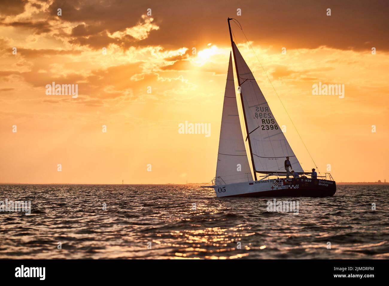 Russia, San Pietroburgo, 05 settembre 2020: La barca a vela solitaria in una lista va dal mare, il cielo di colore rosa, il cielo tempesta Foto Stock Russia, San Pietroburgo, 05 settembre 2020: La barca a vela solitaria in una lista va dal mare, il cielo di colore rosa, il cielo tempesta Foto Stock