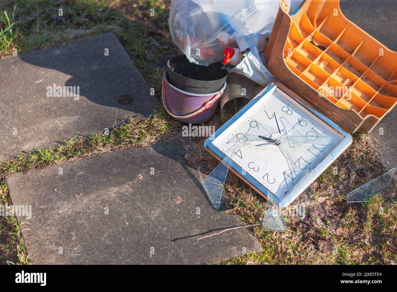 Un mucchio di rifiuti e orologio rotto al centro della composizione, colpo all'aperto Foto Stock