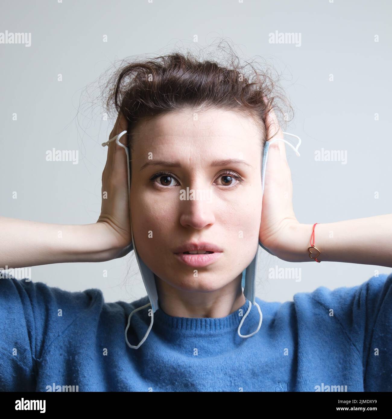 La ragazza copre gli occhi, la bocca e le orecchie con una maschera Foto Stock