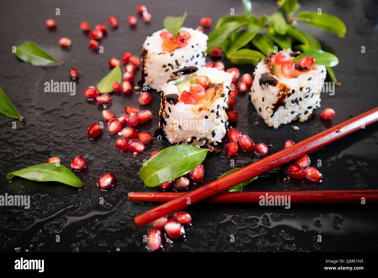 Sushi di riso bianco con semi di melograno Foto Stock