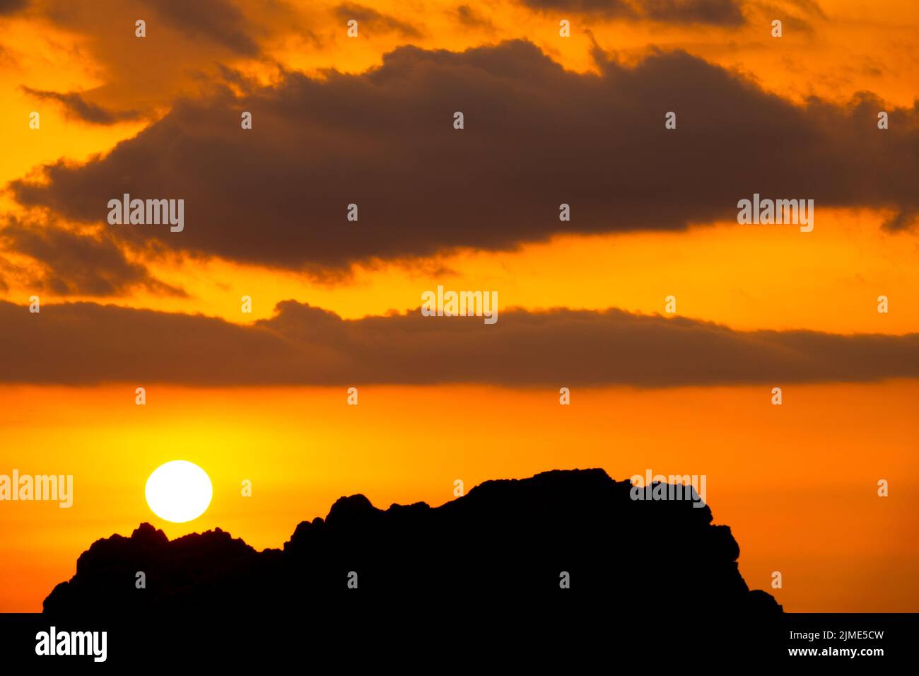 Cielo al tramonto di Bright Orange sulla scogliera Foto Stock