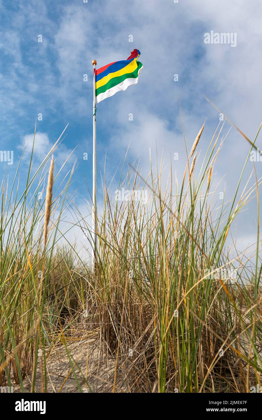 Bandiera di Terschelling su una duna contro un cielo blu con nuvole bianche Foto Stock