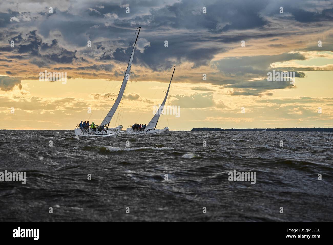 Gara di due barche a vela all'orizzonte in mare al tramonto, il fantastico cielo tempesta di colori diversi, gara, onde grandi, vela r Foto Stock Gara di due barche a vela all'orizzonte in mare al tramonto, il fantastico cielo tempesta di colori diversi, gara, onde grandi, vela r Foto Stock