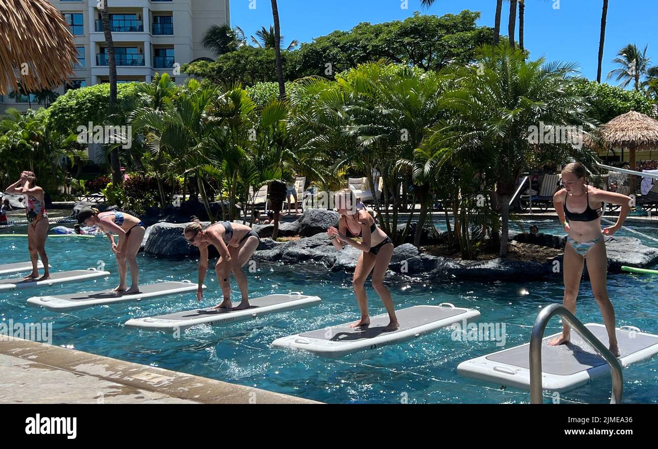 Le donne che partecipano a una classe FloatFit in una piscina in un resort mentre sono in vacanza. Foto Stock