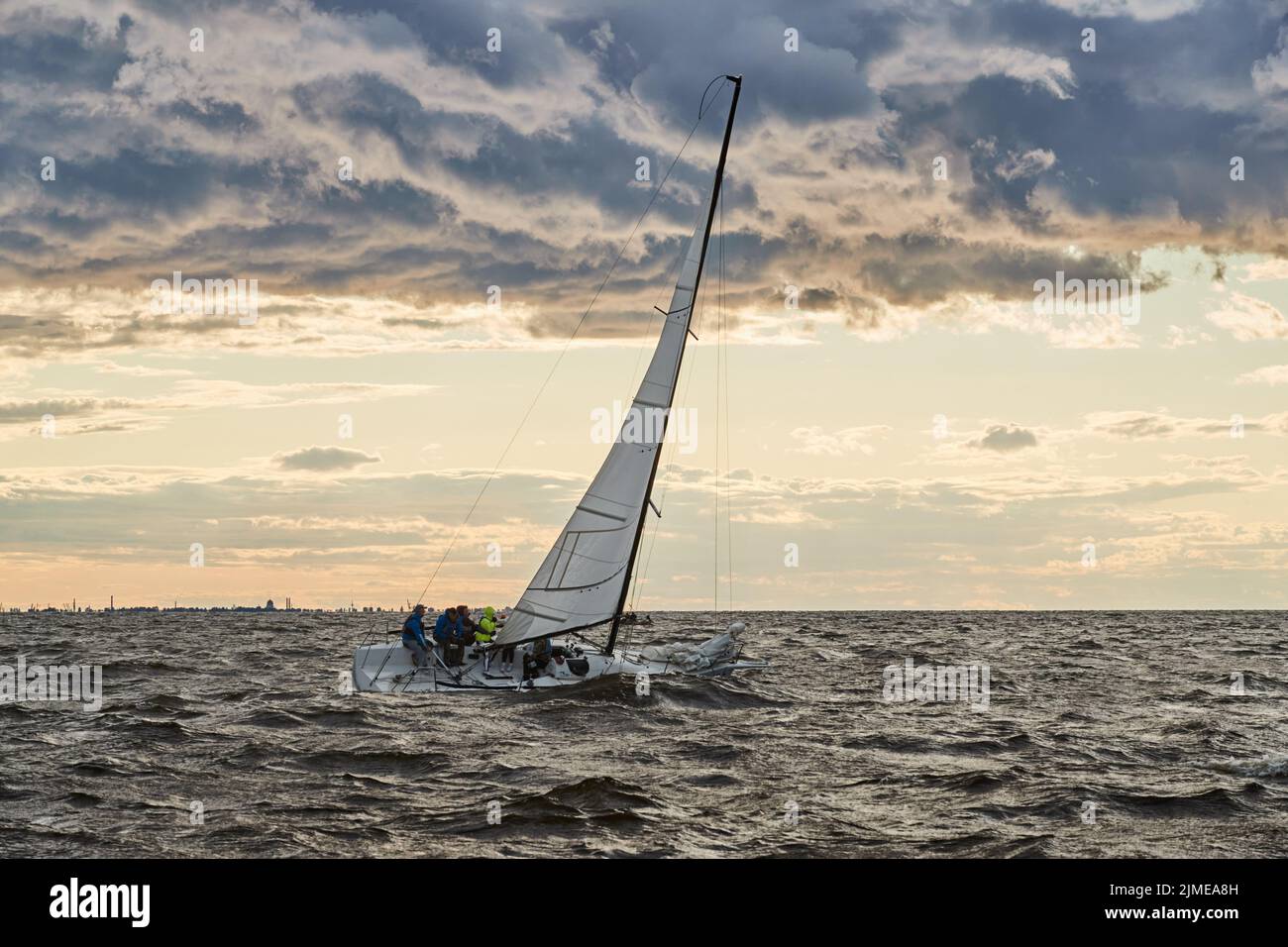 Russia, San Pietroburgo, 23 luglio 2021: La solitaria barca a vela all'orizzonte in mare al tramonto, il cielo tempesta di colori diversi, bi Foto Stock Russia, San Pietroburgo, 23 luglio 2021: La solitaria barca a vela all'orizzonte in mare al tramonto, il cielo tempesta di colori diversi, bi Foto Stock