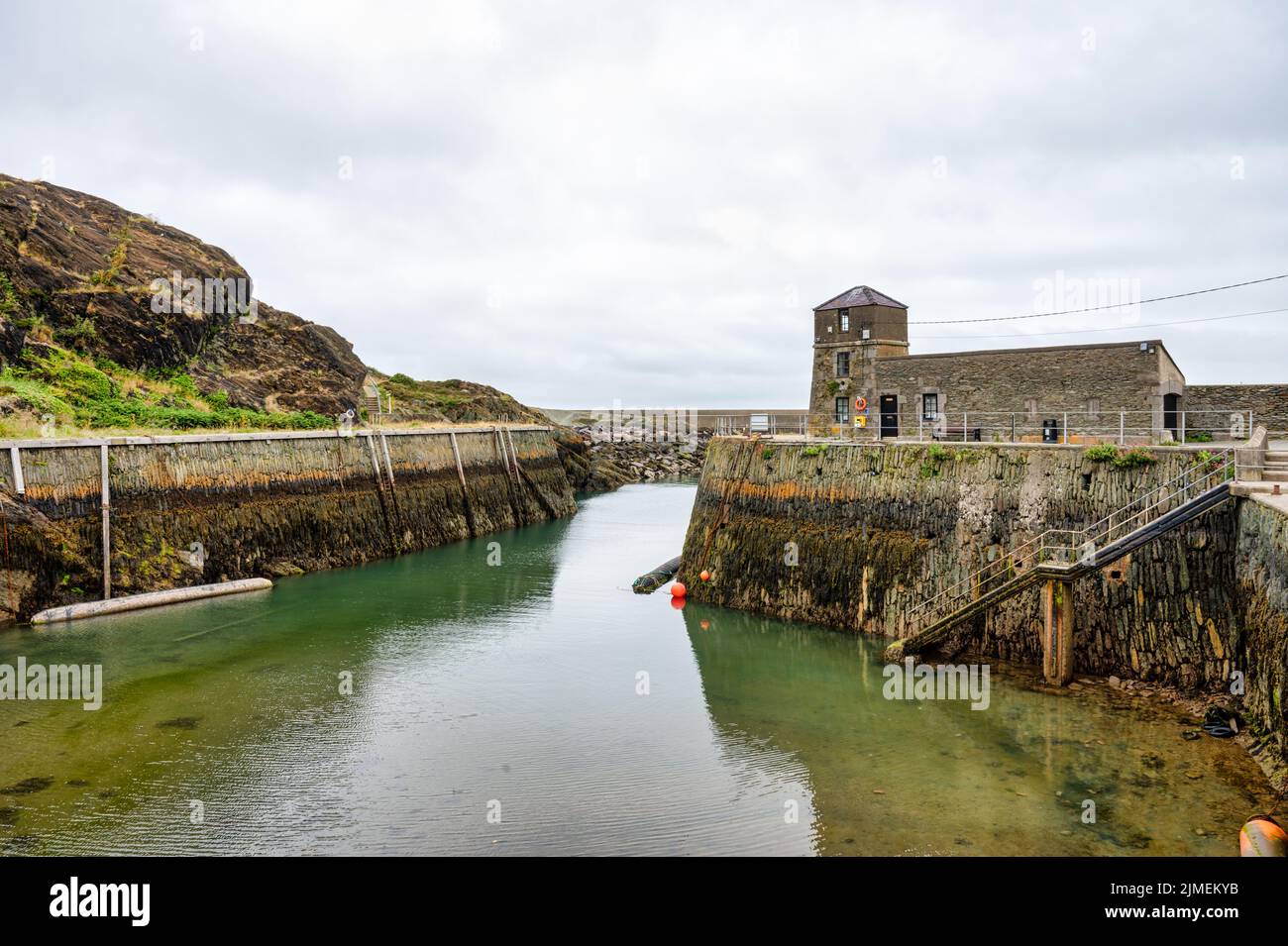 Amlwch, Regno Unito - 8 luglio 2022: I muri di pietra a gradini a lato del porto di Amlch nel Galles del Nord a bassa marea Foto Stock