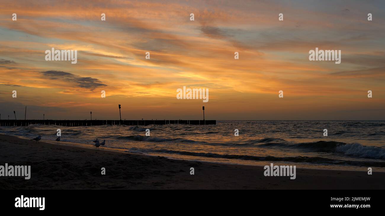 Atmosfera serale sulla spiaggia della costa baltica polacca vicino a Kolobrzeg dopo il tramonto Foto Stock