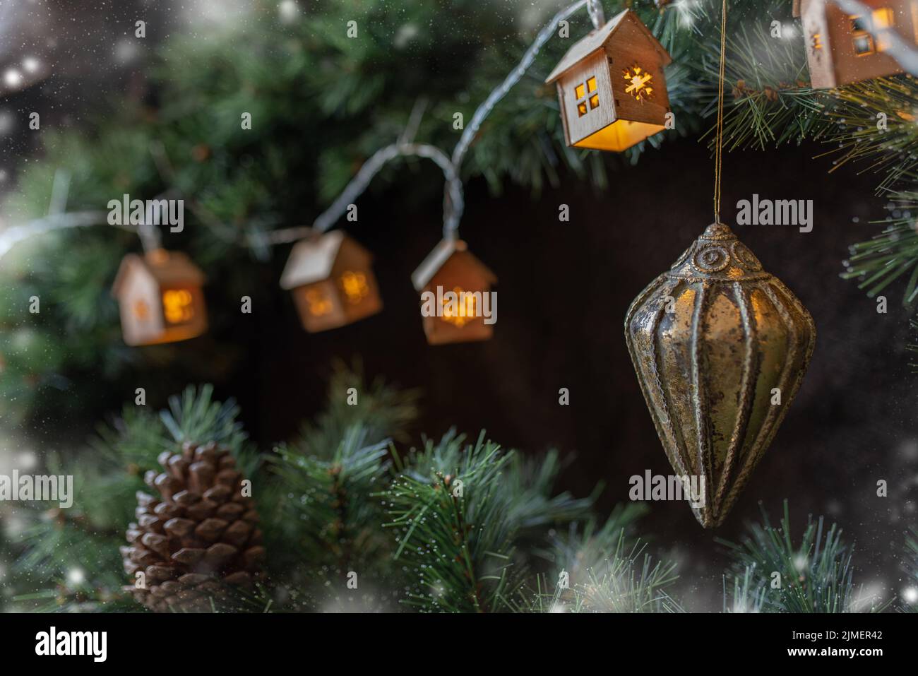 Ghirlanda di alberi di Natale in forma di piccole case scandinave accoglienti su un ramo di abete. Foto Stock