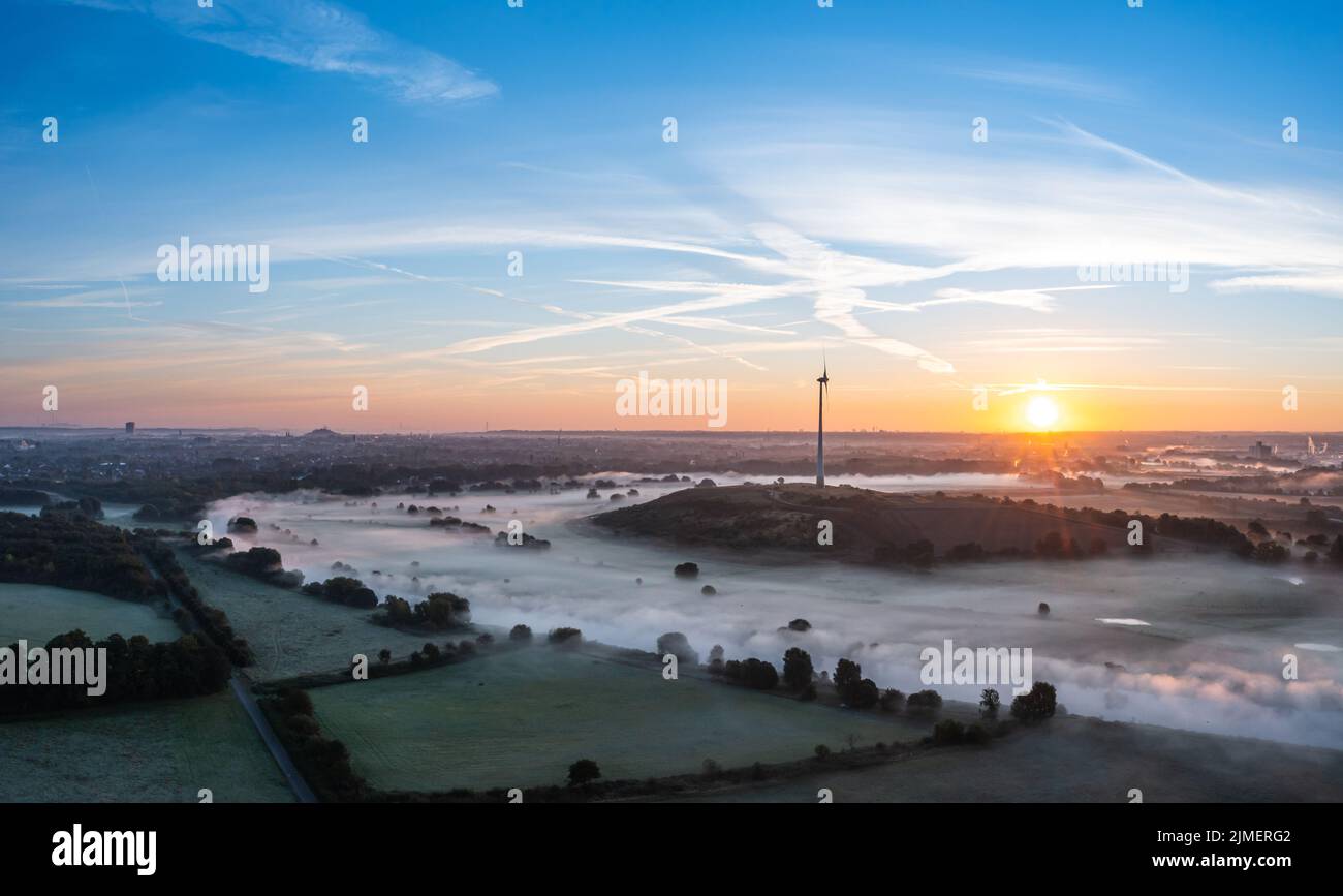 Alba e i primi raggi di sole sui prati coperti di nebbia della Ruhr a Duisburg, Germania Foto Stock