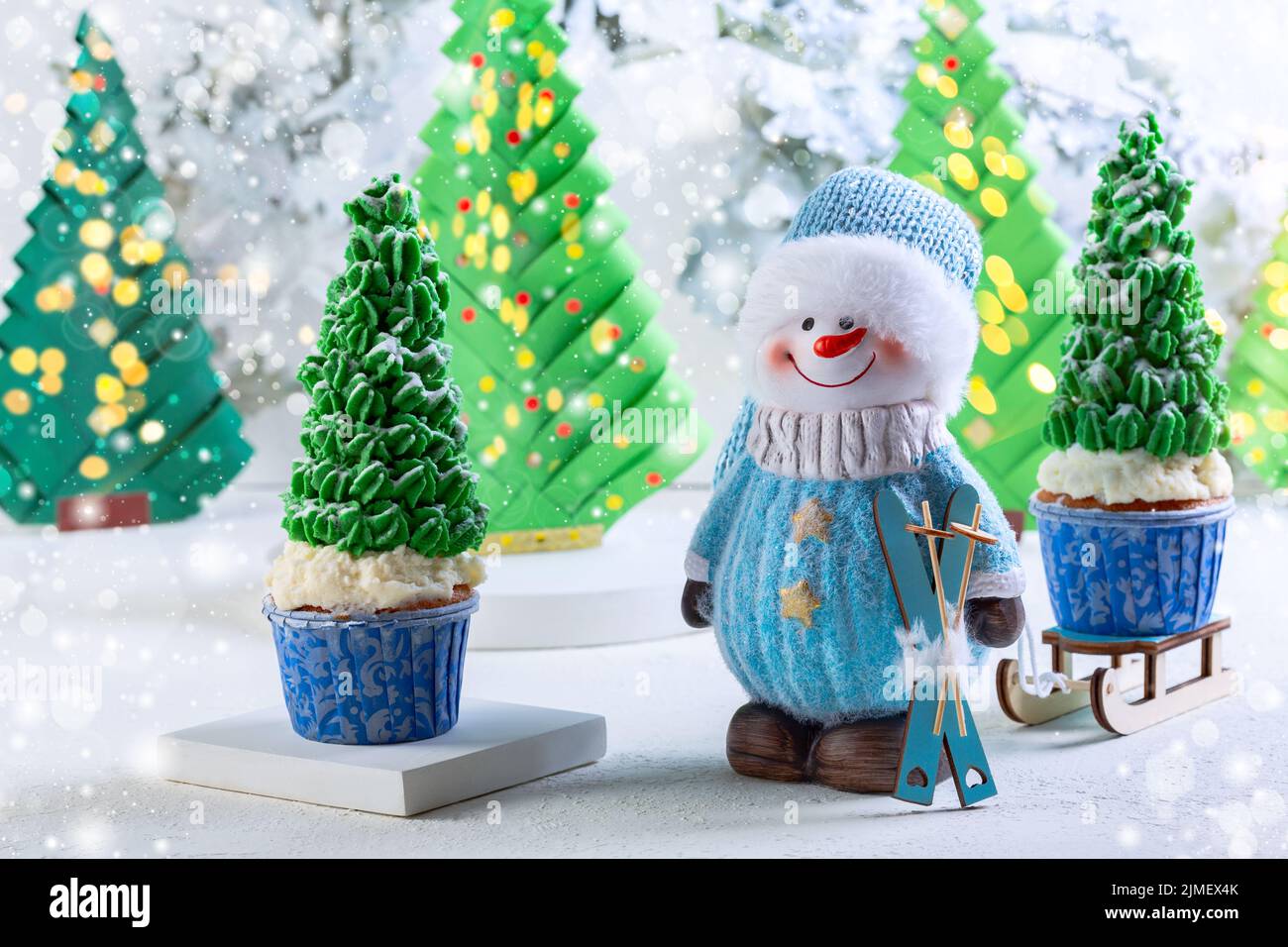 Biglietto di Natale con un pupazzo di neve e cupcakes. Foto Stock