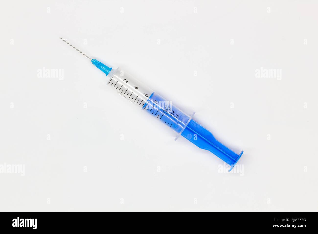 Siringa monouso medica blu per iniezione su sfondo bianco. Strumento medico per la vaccinazione. Siringa da 10 ml per vaccino COVID-19. Medico Foto Stock
