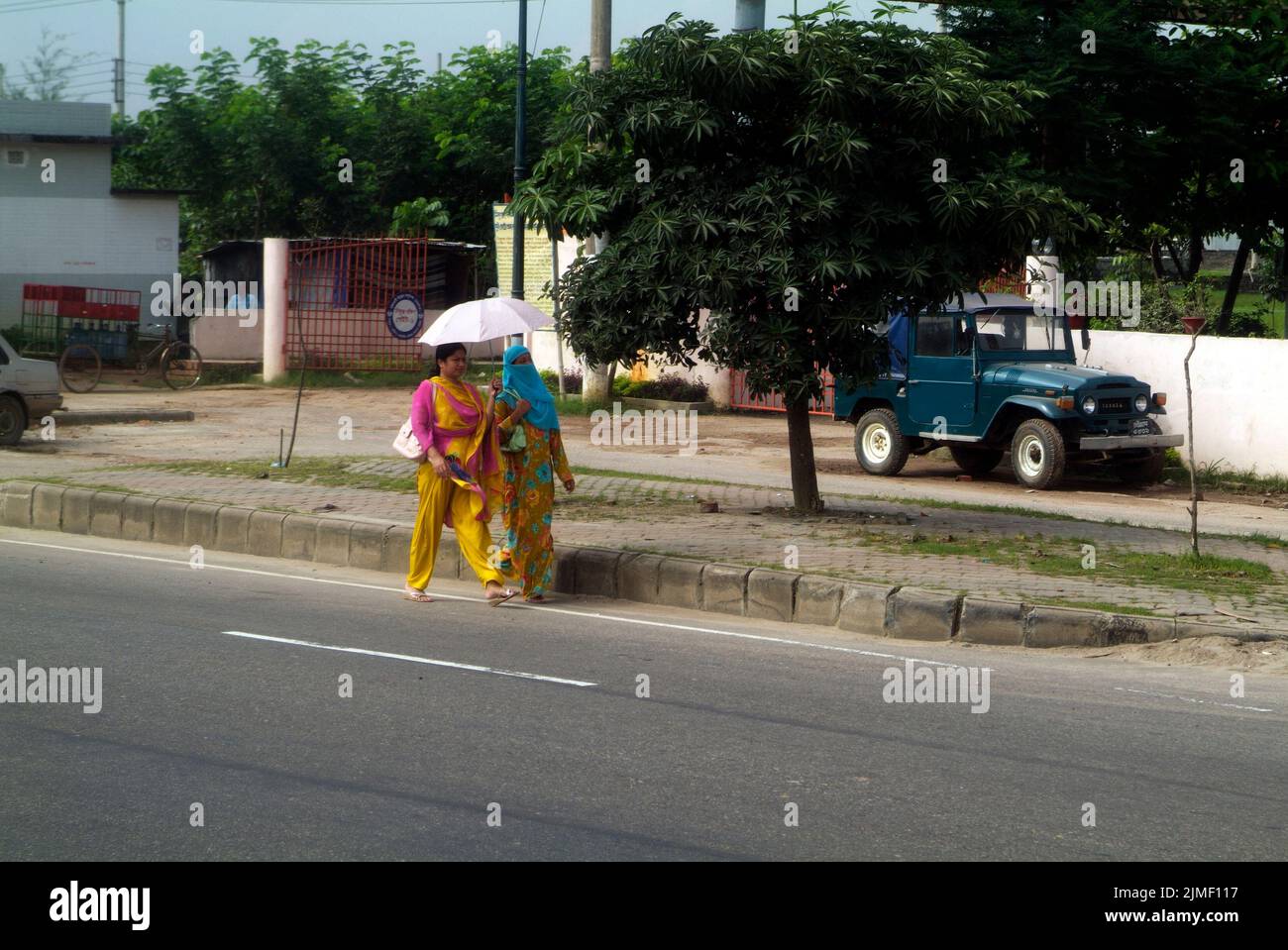Dhaka, Bangladesh - 17 settembre 2007: Due donne non identificate con ombrelloni in abiti tradizionali, una con un velo per motivi religiosi Foto Stock