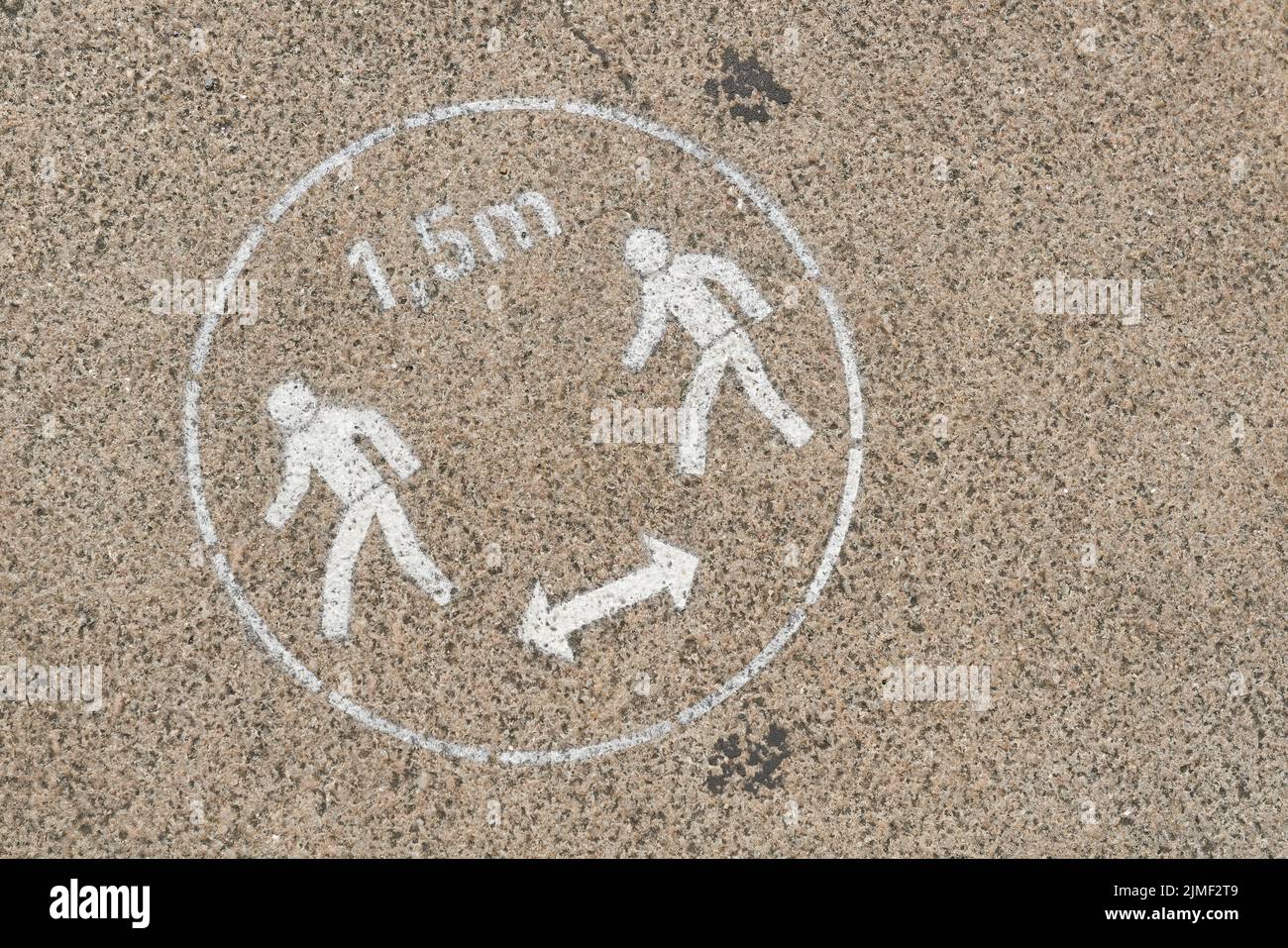 Richiesta di mantenere la distanza di sicurezza a causa della pandemia di Corona su un marciapiede a Berlino Foto Stock