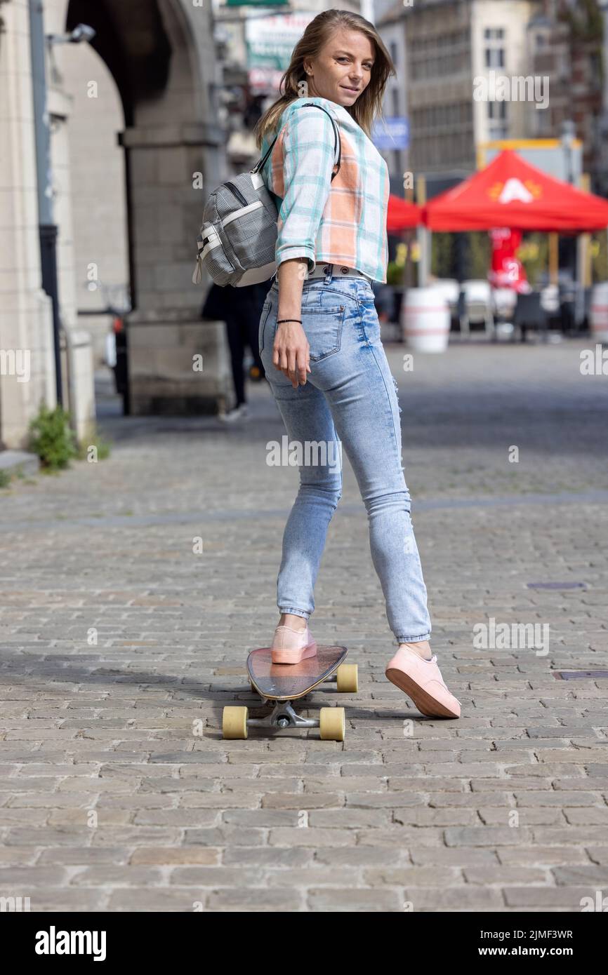 Concetto urbano di generazione moderna, giovane donna alla moda che si diverte con lo scooter elettrico in tutta la città Foto Stock