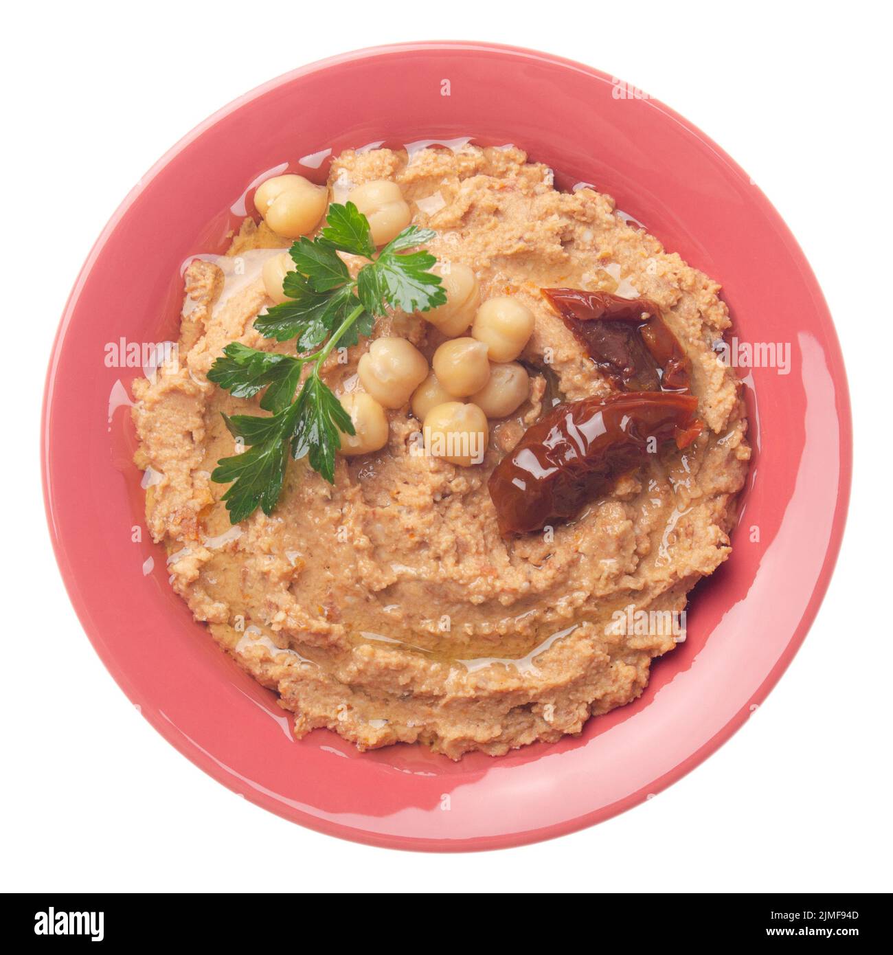 Vista piatta sull'hummus sormontato da fagioli, pomodori secchi e foglie di coriandolo verde isolate su sfondo bianco. Ritaglio Foto Stock