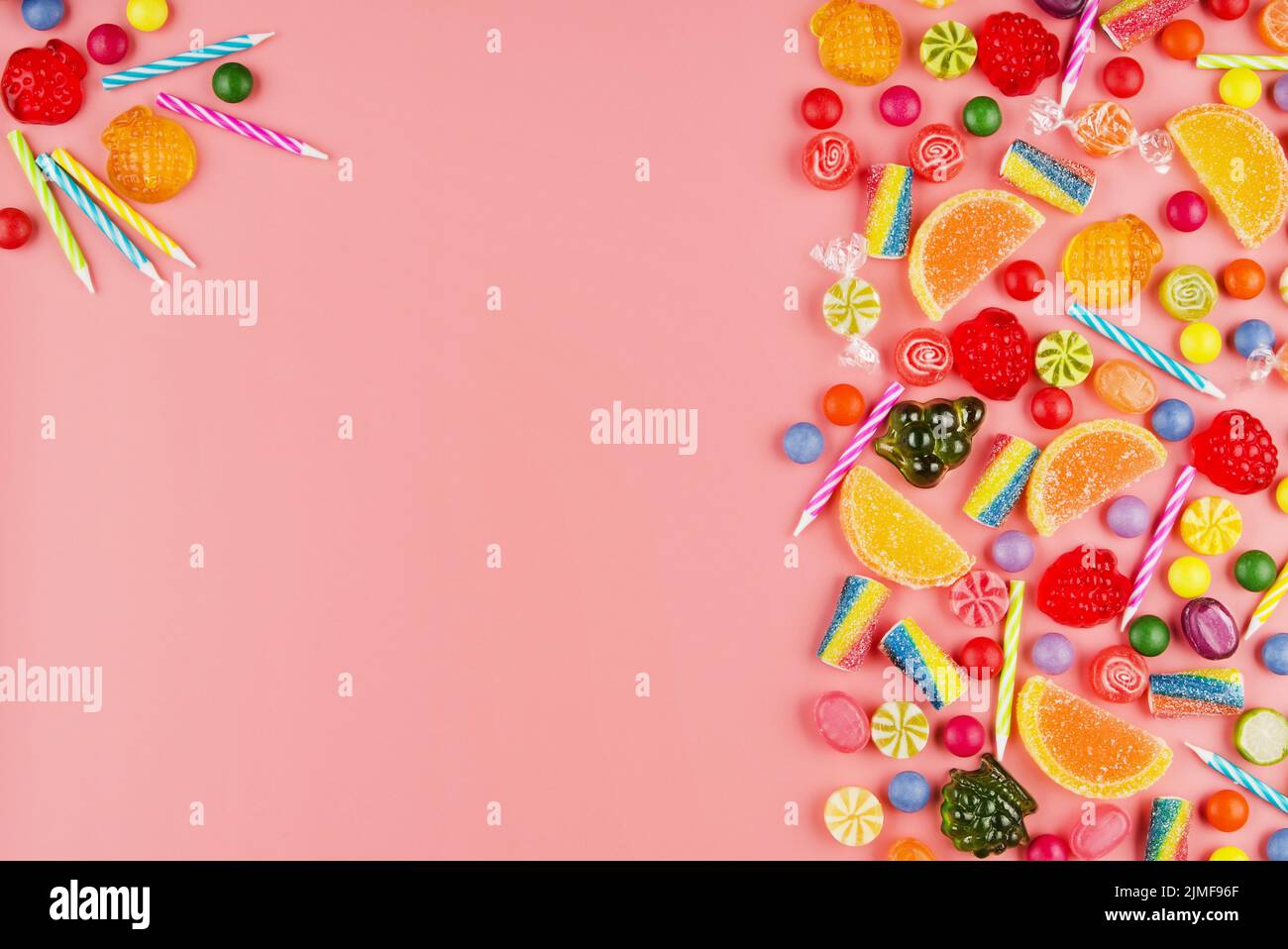 Appartamento vista laici al dolce sfondo di tipo di diverso colore e sapore di caramelle e candeline di compleanno in rosa. Spazio per il testo Foto Stock