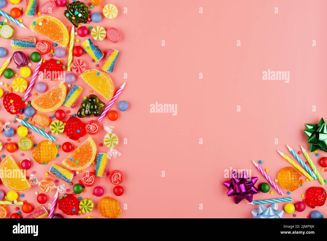 Appartamento vista laici al dolce sfondo di tipo di diverso colore e sapore di caramelle e candeline di compleanno in rosa. Spazio per il testo Foto Stock