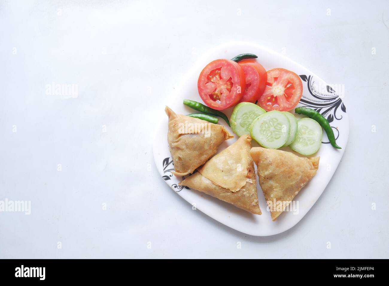 Vista dall'alto della samosa indiana e del pomodoro su un piatto Foto Stock